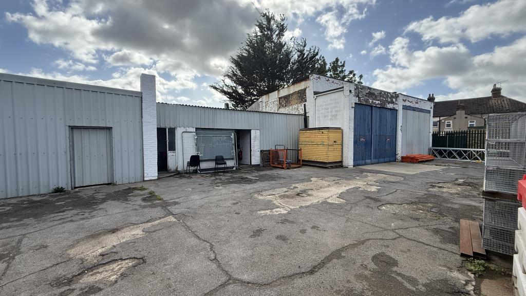 Lot: 34 - YARD, GARAGES AND LIGHT INDUSTRIAL PREMISES WITH POTENTIAL - External image of main buildings from inside fencing